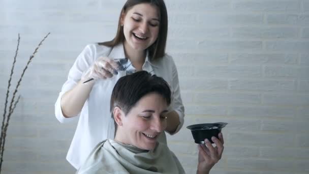 Eine schwangere Friseurin beschäftigt sich mit Haarfärbung in einem Schönheitssalon, professioneller Färbung und Haarpflege, einem Schönheitssalon. — Stockvideo