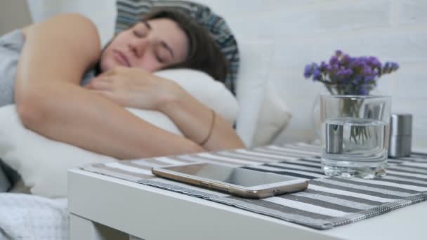 Una chica embarazada duerme en la cama y se distrae con un teléfono celular. El sueño de una chica embarazada — Vídeos de Stock