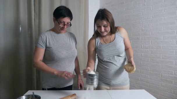 Dotter och mor Cook tillsammans i köket, dotter hjälper mamma knåda degen för pannkakor eller kakor — Stockvideo