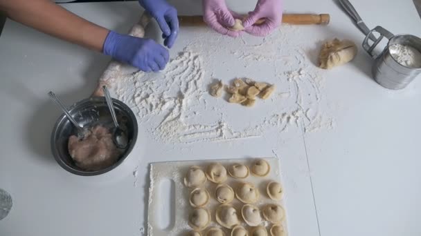 Семья вместе делает пельмени за кухонным столом — стоковое видео