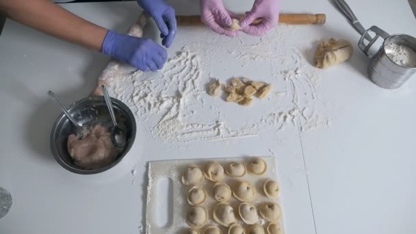 De familie beeldhouwt samen knoedels aan de keukentafel — Stockvideo