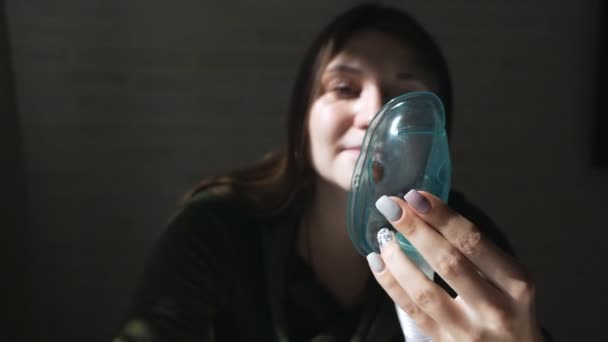 Use un nebulizador e inhalador para el tratamiento. Mujer joven inhalando inhalador a través de una máscara — Vídeos de Stock