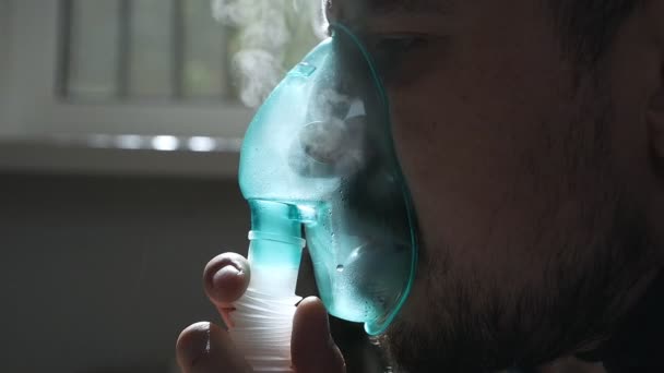 Chorą osobę wdycha się przez inhalator nosowy siedząc na kanapie. Zamknij buzię. Do leczenia należy użyć nebulizatora i inhalatora. — Wideo stockowe