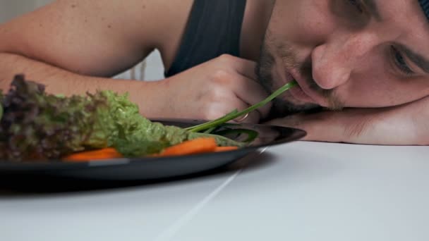 Un vegetariano calvo y gordo come una ensalada asquerosamente. Nutrición adecuada, estilo de vida saludable — Vídeo de stock