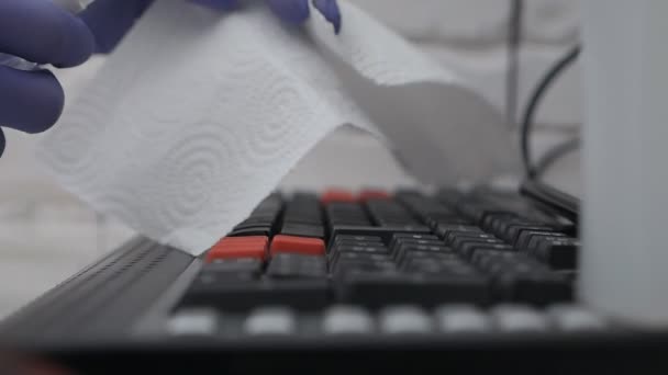 Fermer les mains désinfectant clavier d'ordinateur portable avec pulvérisation antiseptique et essuyer humide dans des gants virus pandémie antibactérienne rester à la maison infection propre assainissant COVID-19 coronavirus . — Video