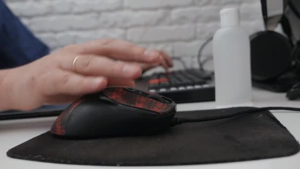 The mans hand works with the mouse on the table and on the keyboard .Remote work, freelancer, workplace — Stock Video