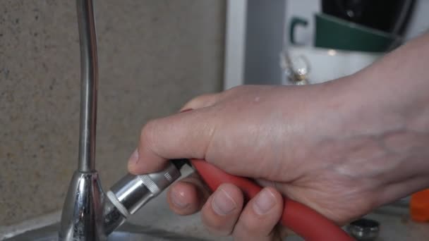 Reparatur von Wasserleitungen nach Wasserlecks. Ein Mann versucht in seiner Wohnung einen Wasserhahn in der Küche zu reparieren — Stockvideo