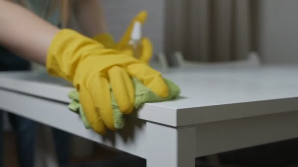 Een vrouw met gele handschoenen die de tafel schoonmaakt. Ontsmettingsmiddel, spray, virusbescherming — Stockvideo