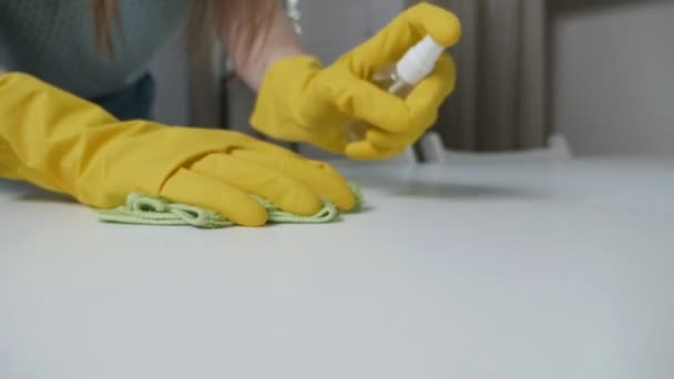 Een vrouw met gele handschoenen die de tafel schoonmaakt. Ontsmettingsmiddel, spray, virusbescherming — Stockvideo