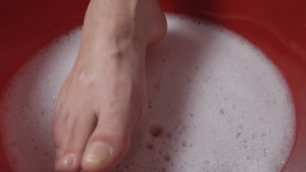 Женщины впитывают пальцы в ванну, пенятся, чтобы расслабиться и подготовиться к стрижке ногтей. — стоковое видео
