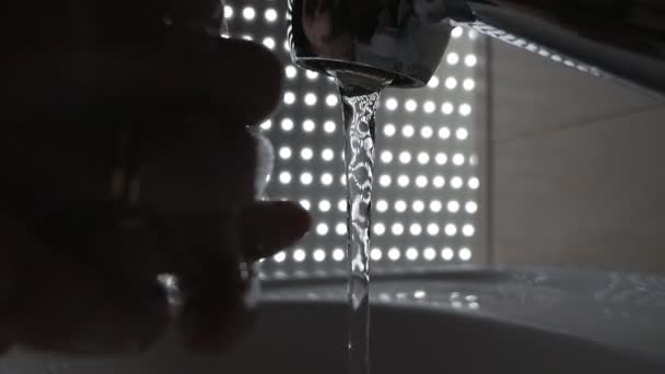 Washing hands under flowing tap water, darkened background — Stock Video