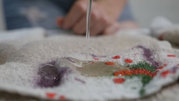 The girl removes stains from paint on the fabric with a stain remover, bleach — Stock Video