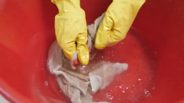 Una mujer lava la ropa, una toalla en un lavabo con un detergente en guantes. Cómo lavar las cosas de pintura — Vídeos de Stock