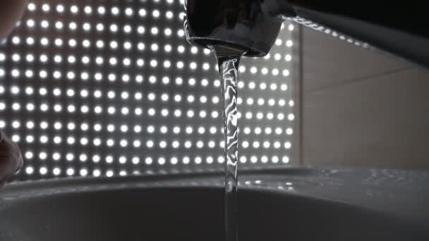 Washing hands under flowing tap water, darkened background — Stock Video