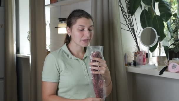 맛있는 이탈리아 소시지를 먹고 있는 젊은 여자가 냄새와 냄새를 맡고 있다 — 비디오