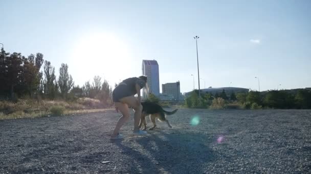 Μια νεαρή γυναίκα τρέχει και παίζει με τον Γερμανό βοσκό της. Γυναίκα σε βόλτα με το σκύλο της. Αργός πυροβολισμός. — Αρχείο Βίντεο