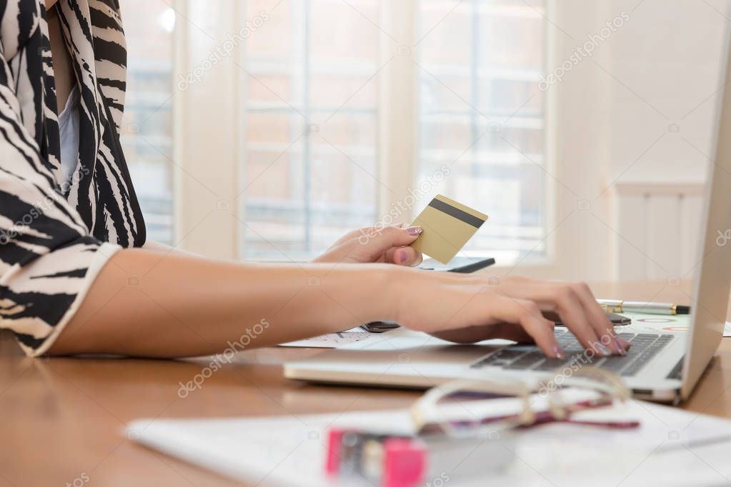 Businesswoman holding credit card and using laptop to shopping online