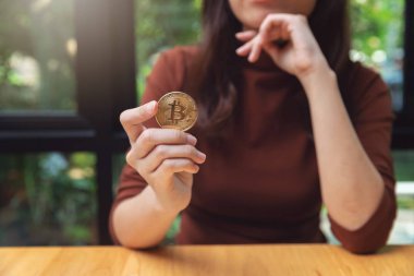 Cryptocurrency altın bitcoin para tutan kadın.
