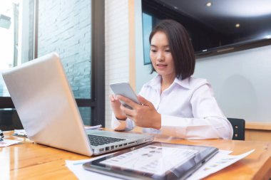 Çalışma, takım çalışması ile ortak iletişim için akıllı telefon kullanarak işkadını office iş ve ekonomi kavramı.