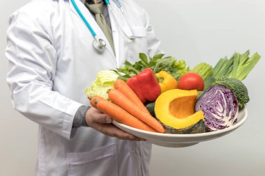 Sağlıklı ve beslenme kavramı. Doktor holding kase taze meyve ve sebze.
