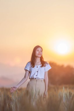 Eğleniyor arpa sahasında günbatımı zaman yaz aylarında güzel Asyalı kadın