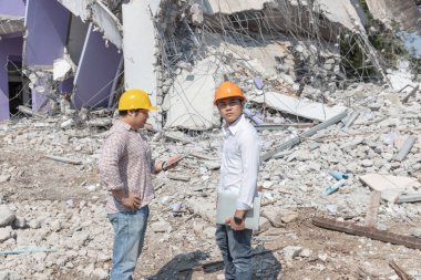 Mühendis ve mimar el sıkışıyor ve işçi kontrolü eski binayı yıkıyor..