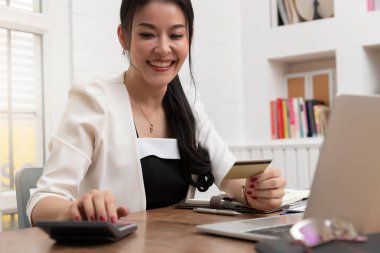 Freelancer iş kadını kafede online alışveriş için bilgisayar laptop ve kredi sepeti kullanarak.