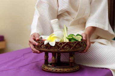 Asyalı bir kadın masaj için elinde tuz fırçası tutuyor..