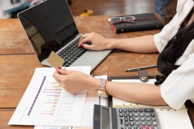 Freelancer iş kadını kafede online alışveriş için bilgisayar laptop ve kredi sepeti kullanarak.