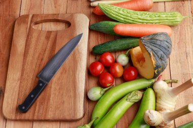 Tayland mutfağı. Ahşap zemin üzerinde boş sayfa ve kalem bulunan çeşitli sebzeler, baharatlar ve malzemeler..