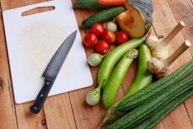 Tayland mutfağı. Ahşap zemin üzerinde boş sayfa ve kalem bulunan çeşitli sebzeler, baharatlar ve malzemeler. Kopyalama alanı olan üst görünüm