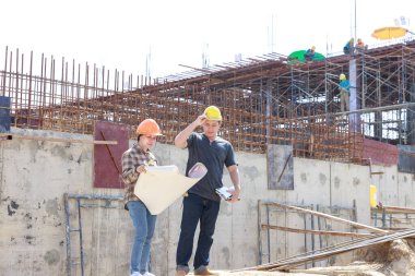 İnşaat mühendisi ve mimar inşaat alanında mavi baskı ile çalışma kavramı