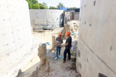 İnşaat mühendisi ve mimar inşaat alanında mavi baskı ile çalışma kavramı