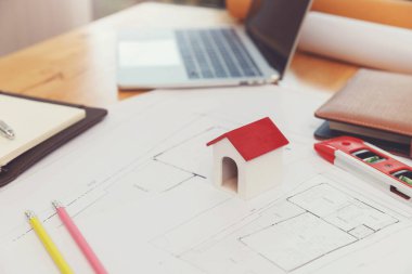Engineer and Architect concept, Close up house model on Interior designer desk with blueprint