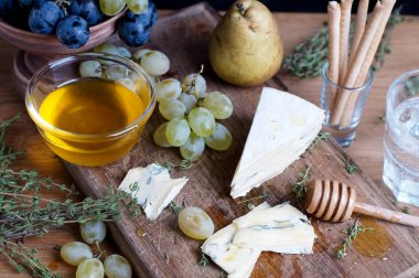 Üzüm, bal ve bir ahşap zemin üzerine armut ile mavi peynir servis