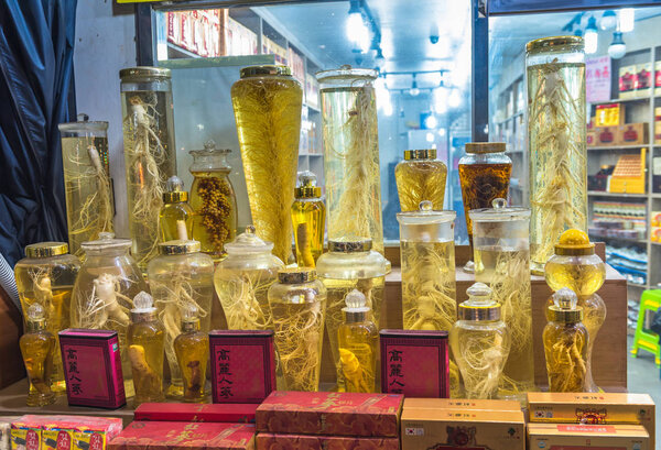 SEOUL SOUTH KOREA - APRIL 7, 2018: Store of extracts of ginseng and other roots in the glass bottles. Namdaemun Market in Seoul is the oldest and largest market in South Korea. 