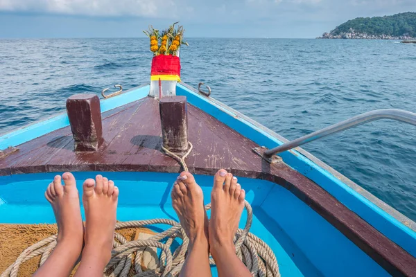 Füße von Kind und Mutter am traditionellen thailändischen Langschwanzboot lizenzfreie Stockbilder