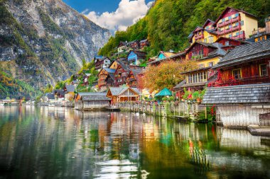 Hallstattersee gölde yansıtan ünlü Hallstatt lakeside kasaba güneşli sonbahar gün. Yer: resort köyü Hallstatt, Salzkammergut bölge, Avusturya, Alpler. Europe... Yer: resort köyü Hallstatt, Salzkammergut bölge, Avusturya, Alpler. Europe.