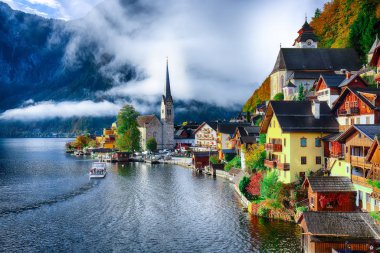 Sisli sonbahar gün doğarken Hallstattersee gölde yansıtan ünlü Hallstatt lakeside kasaba. Yer: resort köyü Hallstatt, Salzkammergut bölge, Avusturya, Alpler. Europe... Yer: resort köyü Hallstatt, Salzkammergut bölge, Avusturya, Alpler. EUR