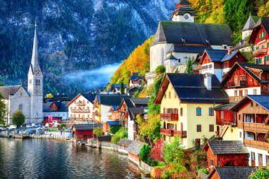 Sisli sonbahar gün doğarken Hallstattersee gölde yansıtan ünlü Hallstatt lakeside kasaba. Yer: resort köyü Hallstatt, Salzkammergut bölge, Avusturya, Alpler. Europe... Yer: resort köyü Hallstatt, Salzkammergut bölge, Avusturya, Alpler. EUR