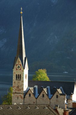 Hallstatt'ın yerlerinden biri kilise Saat Kulesi ayakta dağ arka plan görüntüleyin. Yer: resort köyü Hallstatt, Salzkammergut bölge, Avusturya, Alpler. Europe.