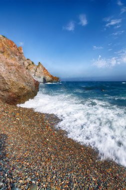 Kıyıda çökmesini ve sahil çakıl akan deniz dalgaları. Kayalık deniz kıyısı