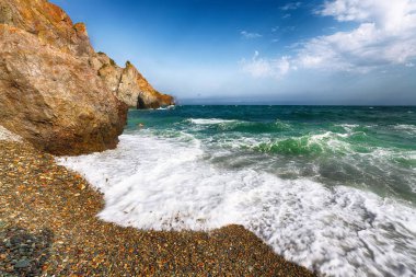 Kıyıda çökmesini ve sahil çakıl akan deniz dalgaları. Kayalık deniz kıyısı