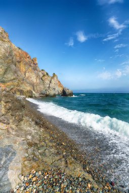 Kıyıda çökmesini ve sahil çakıl akan deniz dalgaları. Kayalık deniz kıyısı