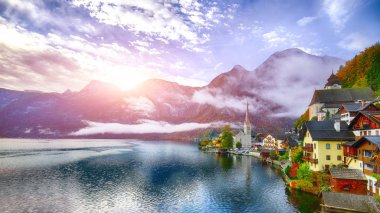 Sisli sonbahar gün doğarken Hallstattersee gölde yansıtan ünlü Hallstatt lakeside kasaba. Yer: resort köyü Hallstatt, Salzkammergut bölge, Avusturya, Alpler. Europe... Yer: resort köyü Hallstatt, Salzkammergut bölge, Avusturya, Alpler. EUR