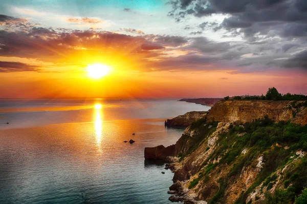 Cape Fiolent 'te gün batımında çimenler ve kayalar ön planda. Kırım