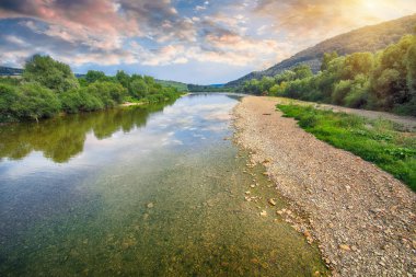 Buzlu suda suda mavi gökyüzü ve ayna yansıması ile dağ nehir akış. Kayalar ile açık Nehri dağ Güneş tarafından yaktı doğru yol açar. Karpat bölge. Ukrayna