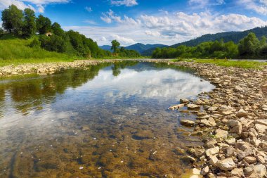 Buzlu suda suda mavi gökyüzü ve ayna yansıması ile dağ nehir akış. Kayalar ile açık Nehri dağ Güneş tarafından yaktı doğru yol açar. Karpat bölge. Ukrayna