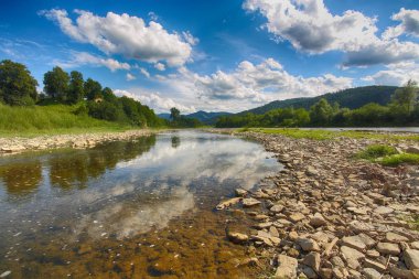 Buzlu suda suda mavi gökyüzü ve ayna yansıması ile dağ nehir akış. Kayalar ile açık Nehri dağ Güneş tarafından yaktı doğru yol açar. Karpat bölge. Ukrayna