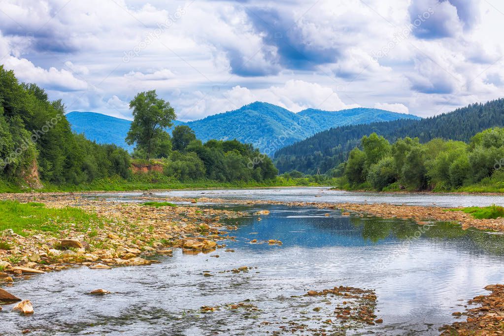 Mountain river stream of water in the rocks with majestic stormy sky. Clear river with rocks. Stone foreground. Carpathian region. Ukraine